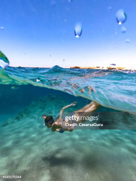 la donna si gode lo snorkeling nel mar rosso - half underwater foto e immagini stock