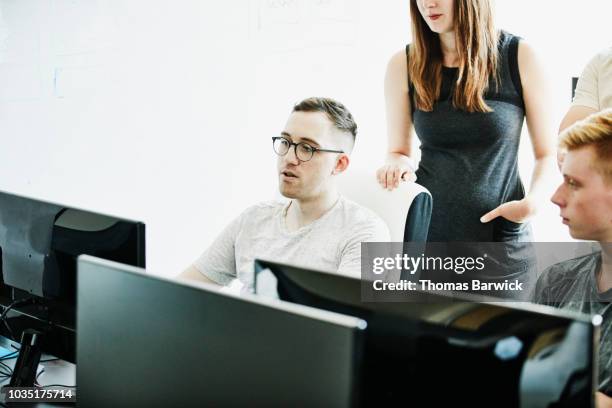 engineer leading discussion with coworkers while solving coding problem - world at your fingertips stockfoto's en -beelden