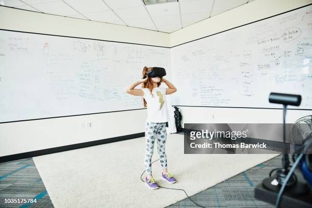 Young girl using virtual reality headset in computer lab