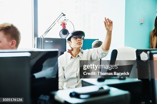 Female engineer testing program on augmented reality headset in computer lab Female engineer testing program on augmented reality headset in computer lab