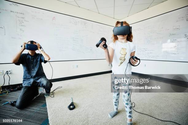 young girl using virtual reality headset to test program in computer lab - girls in leggings stockfoto's en -beelden