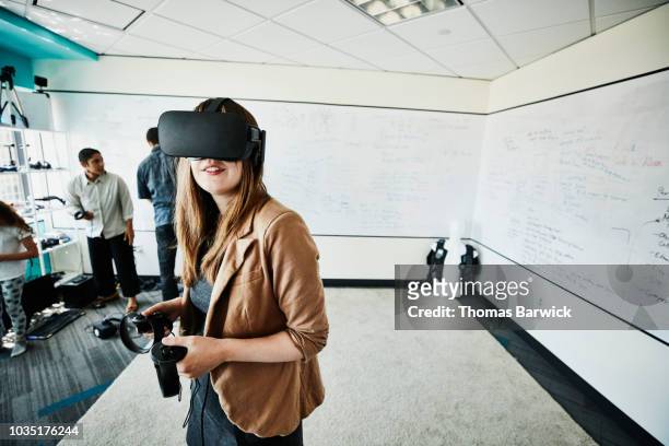female engineer using virtual reality headset in computer lab - kid office stock-fotos und bilder