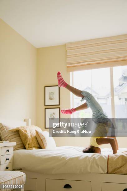 jeune africaine américaine faisant headstand sur lit - saut périlleux photos et images de collection