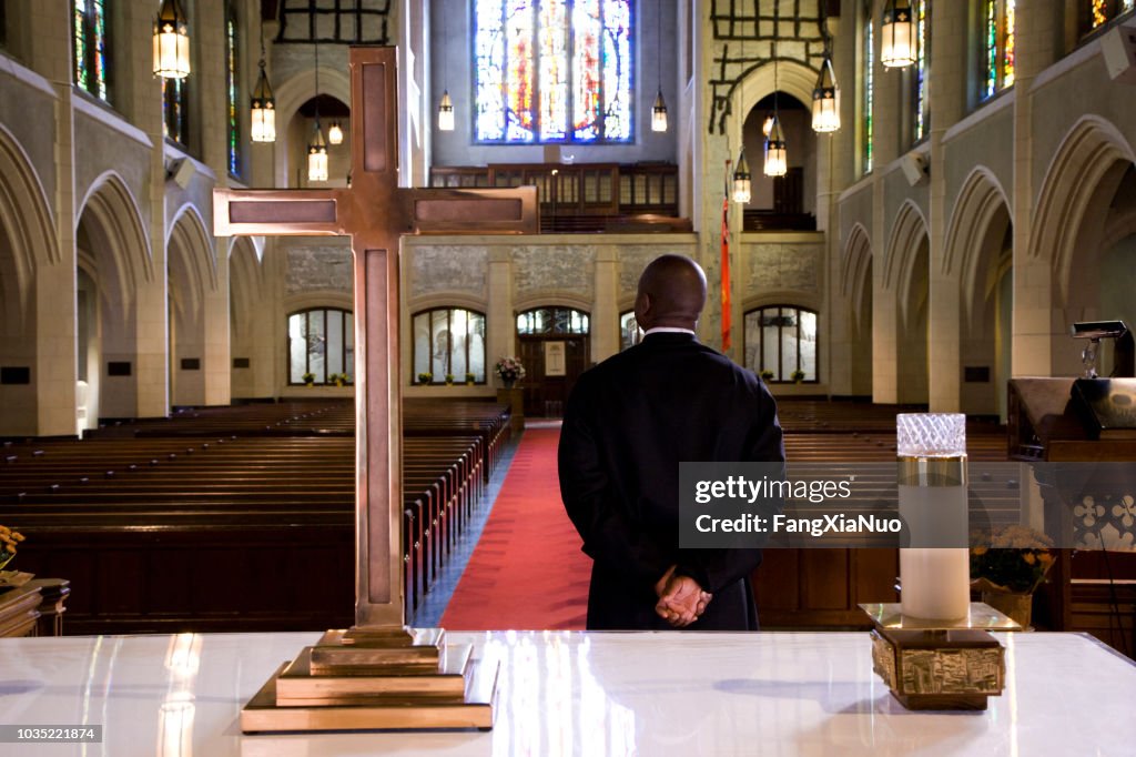 Priest waiting for a sign in church