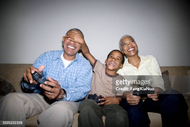 grands-parents africains jeu vidéo avec petit-fils - taquiner photos et images de collection