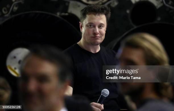 SpaceX CEO Elon Musk listens to a question at a press conference where he announced the Japanese billionaire chosen by the company to fly around the...