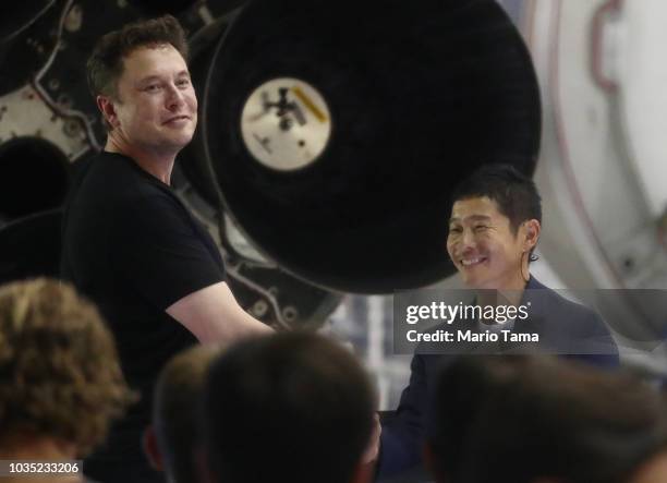 SpaceX CEO Elon Musk shakes hands with Yusaka Maezawa, the Japanese billionaire chosen by the company to fly around the moon, on September 17, 2018...