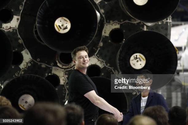 Elon Musk, chief executive officer for Space Exploration Technologies Corp. , left, shakes hands with Yusaku Maezawa, founder and president of Start...