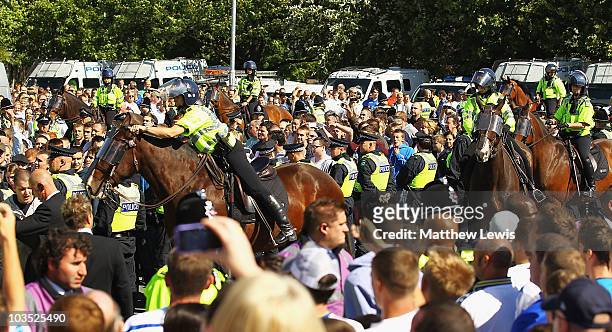 Police escort the Millwall supporters into the ground ahead of the Npower Championship match between Leeds United and Millwall at Elland Road on...