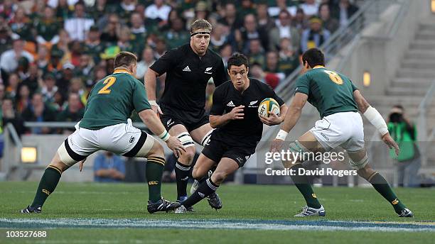 Dan Carter of the All Blacks races past John Smit and Pierre Spies during the 2010 Tri-Nations match between the South African Springboks and the New...