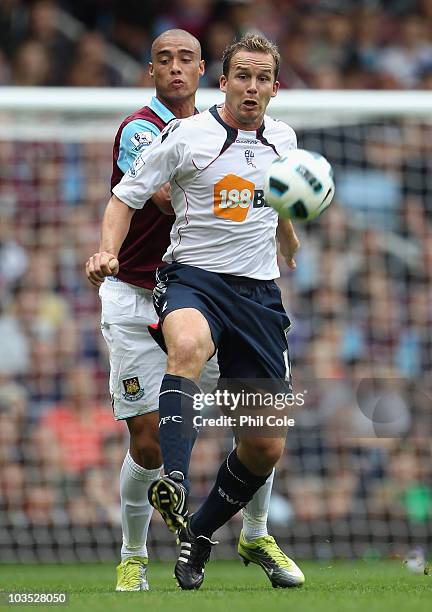 Kevin Davies of Bolton Wanderers is challenged by Winston Reid of West Ham United during the Barclays Premier League match between West Ham United...