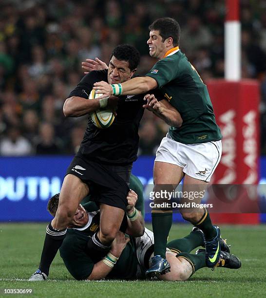 Mils Muliaina of the All Blacks is tackled by John Smit and Morne Steyn during the 2010 Tri-Nations match between the South African Springboks and...