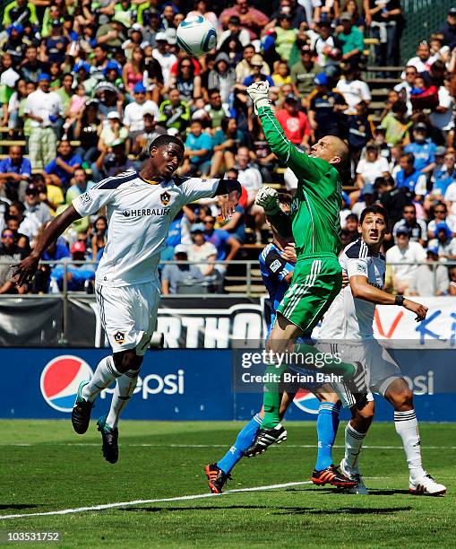 Goalie Jon Busch of the San Jose Earthquakes punches the ball away from Edson Buddle of the Los Angeles Galaxy on August 21, 2010 at Buck Shaw...