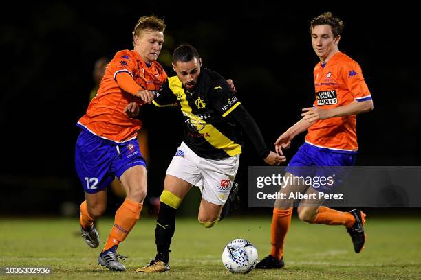 Adrian Zahra of Heidelberg United dribbles past Shaun Carlos and Mitchell Hore of Lions FC during the NPL Semi Final match between Lions FC and...