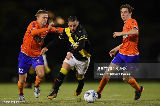 Adrian Zahra of Heidelberg United dribbles past Shaun Carlos and Mitchell Hore of Lions FC during the NPL Semi Final match between Lions FC and...