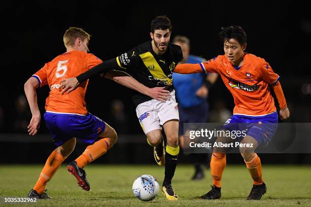 Andrew Cartanos of Heidelberg United dribbles past Tommy Jarrard and Danny Kim of Lions FC during the NPL Semi Final match between Lions FC and...