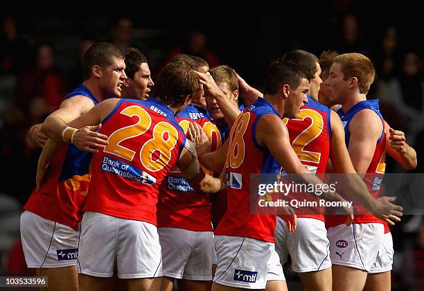 Jonathan Brown of the Lions is congratulated by team-mates after kicking a goal during the round 21 AFL match between the Essendon Bombers and the...