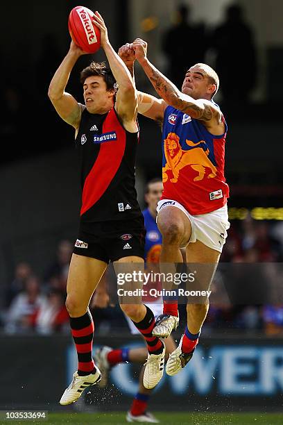 Angus Monfries of the Bombers attempts to mark infront of Ashley McGrath of the Lions during the round 21 AFL match between the Essendon Bombers and...