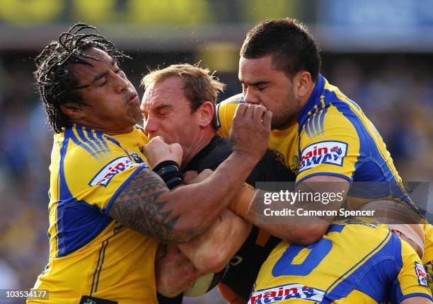 Gareth Ellis of the Tigers is tackled during the round 24 NRL match between the Parramatta Eels and the Wests Tigers at Parramatta Stadium on August...