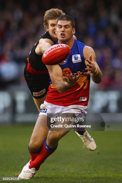 Jonathan Brown of the Lions marks infront of Michael Hurley of the Bombers during the round 21 AFL match between the Essendon Bombers and the...