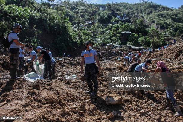 Filipino rescuers dig at the site where dozens of people were believed to have been buried by a landslide on September 18, 2018 in in Itogon, Benguet...