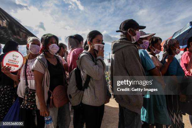 Families wait to claim the bodies of their loved ones who were killed by a landslide on September 18, 2018 in in Itogon, Benguet province,...