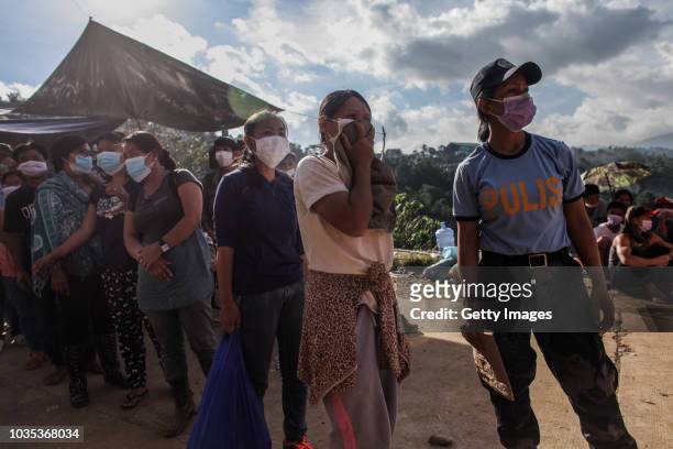 Families wait to claim the bodies of their loved ones who were killed by a landslide on September 18, 2018 in in Itogon, Benguet province,...