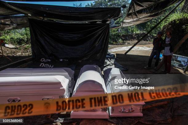 Coffins that will be used for the people who were killed by a landslide are seen inside a tent on September 18, 2018 in in Itogon, Benguet province,...