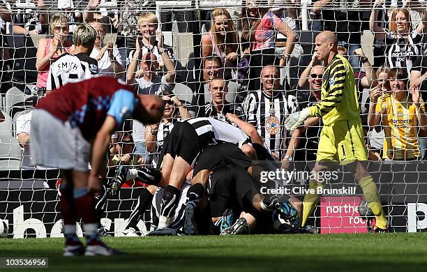 Brad Friedel and Stephen Ireland of Aston Villa show their dejection after Kevin Nolan of Newcastle United celebrate under his team mates after...