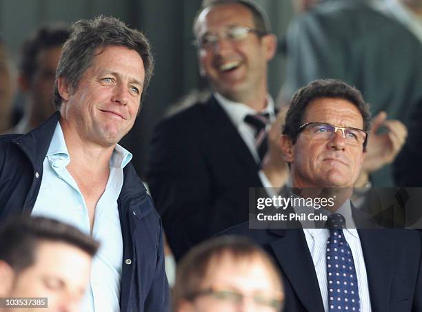 England manager Fabio Capello and actor Hugh Grant look on prior to the Barclays Premier League match between Fulham and Manchester United at Craven...