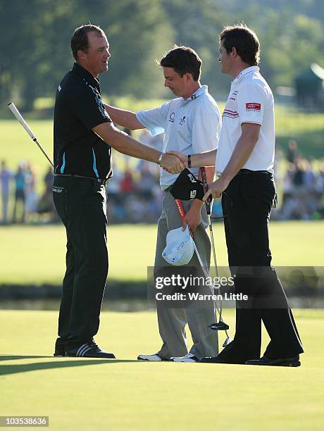 Peter Hanson of Sweden is congratulated by Peter Lawrie of Ireland and Gary Boyd of England after winning the Czech Open 2010 on the second play-off...