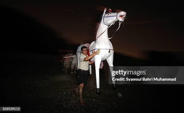 Member of the Chinese ethnic community carries a paper-made horse during the Chinese Hungry Ghost Festival on August 22, 2010 in Shah Alam, Malaysia....