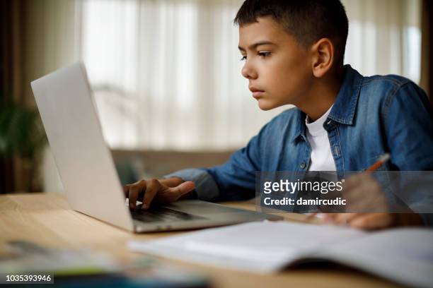 teenage boy using laptop for homework - boys stock pictures, royalty-free photos & images