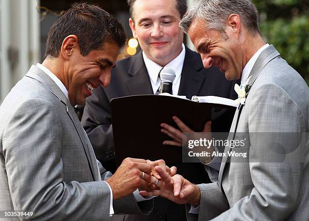 Reporter Roby Chavez exchanges rings with his partner Chris Roe during their wedding ceremony, officiated by Rev. Dwayne Johnson of Metropolitan...