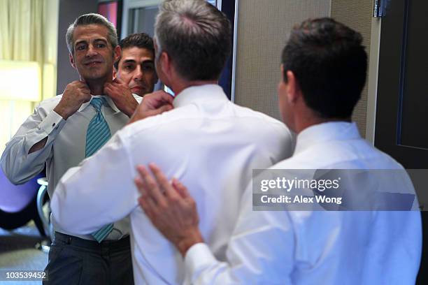 Reporter Roby Chavez looks on as his partner Chris Roe adjusts his shirt collar while getting dress in their hotel room for their wedding ceremony...