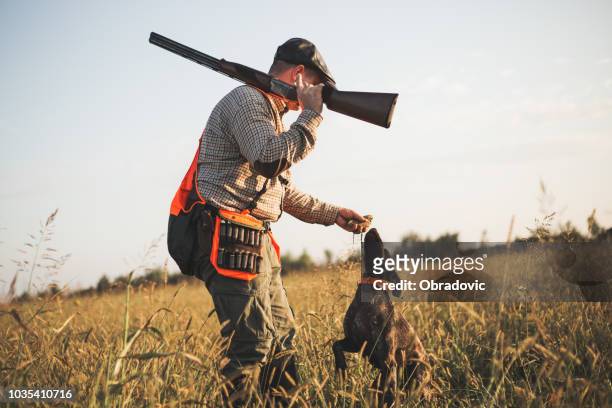 jäger mit apportierhund während der hunt - hunting sport stock-fotos und bilder