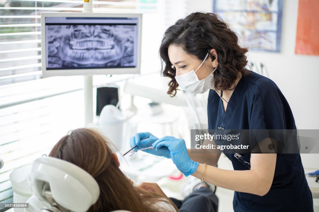 Female dentist talking to her patient at dentist's office