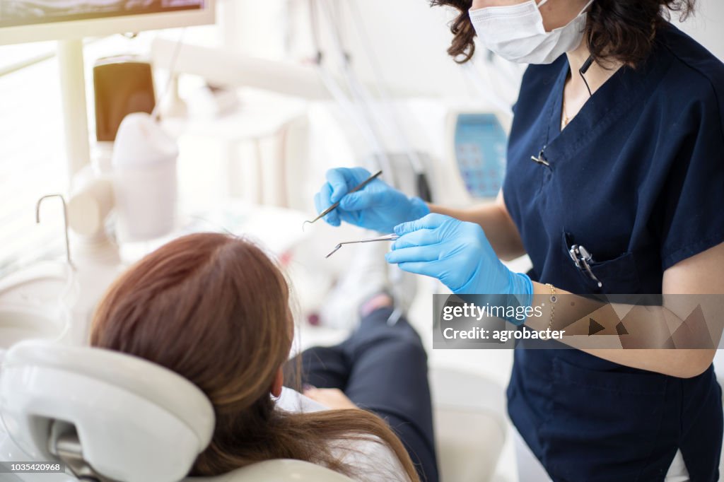 Female dentist talking to her patient at dentist's office