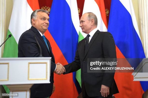 Hungarian Prime Minister Viktor Orban shakes hands with Russian President Vladimir Putin during their joint press conference following their meeting...