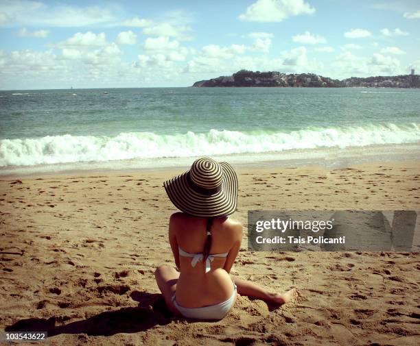 woman sitting on beach - acapulco stock-fotos und bilder