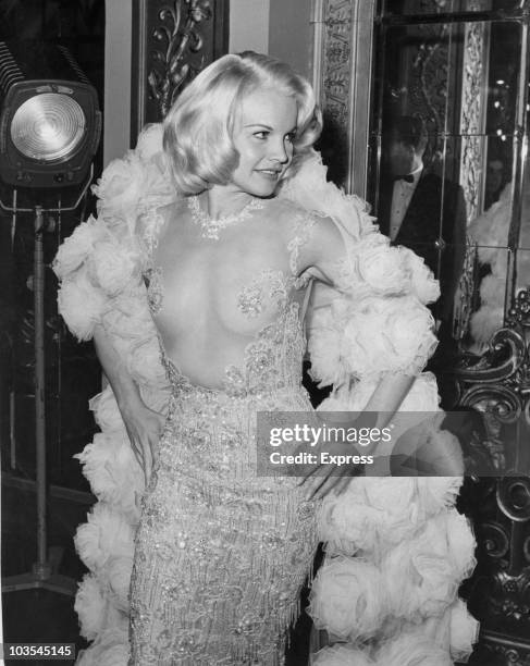 Actress Carroll Baker pictured attending the London premier of the film, 'The Carpetbaggers', at the Plaza Cinema, London, 21 October 1964. Baker is...