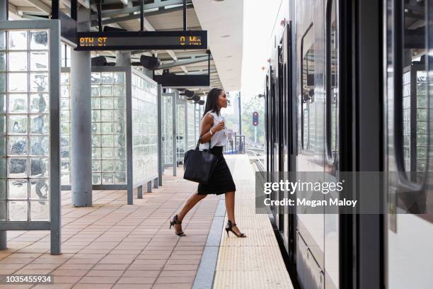 businesswoman boarding train - lightrail stock-fotos und bilder