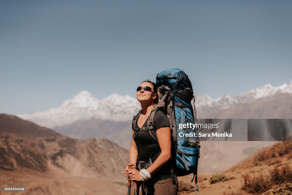 Hiker on peak, Annapurna Circuit, the Himalayas,  Dhaulagiri and Tukuche mountains in background, Muktinath, Nepal