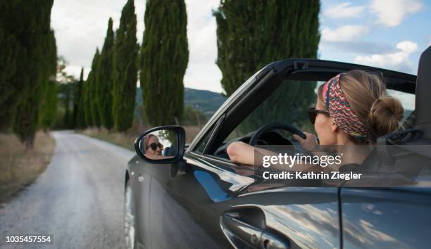 woman driving convertible car on tuscan country road, italy - driving in europe stock pictures, royalty-free photos & images