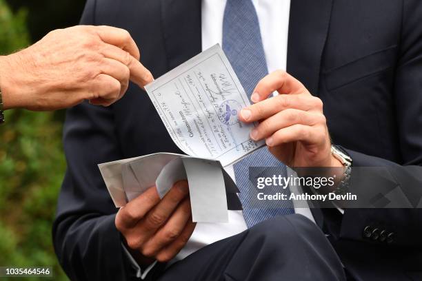 Prince William, Duke of Cambridge speaks with Michael Mamelock and views his emigration papers as he meets families of those helped by Major Frank...