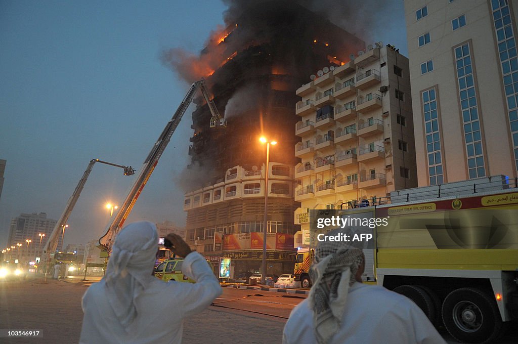 Emirati men watch the flames and smoke a