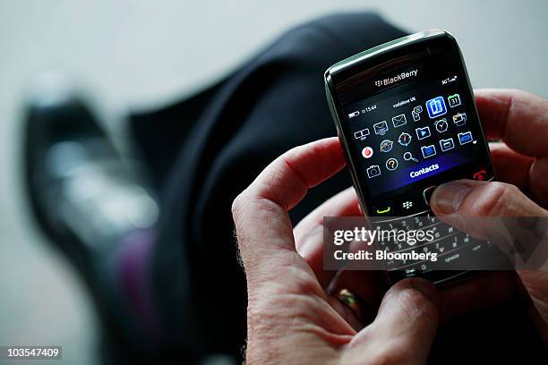 Businessman browses the folder menu on a BlackBerry Bold handset, made by Research In Motion Ltd. In this arranged photograph in London, U.K., on...