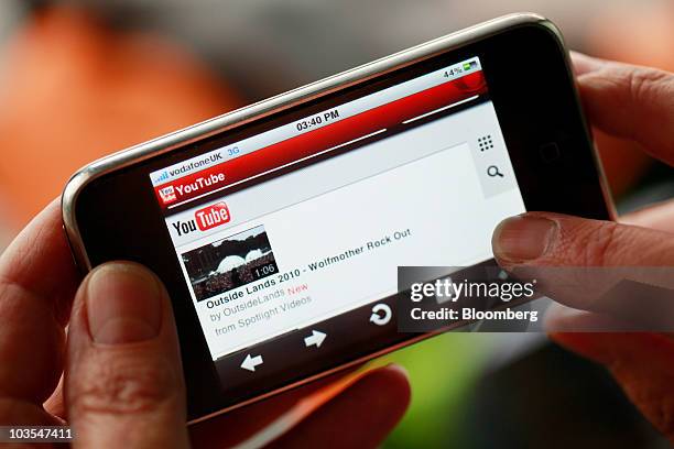 Businessman browses Google Inc.�s YouTube website using an Apple iPhone, made by Apple Inc., in this arranged photograph in London, U.K., on...