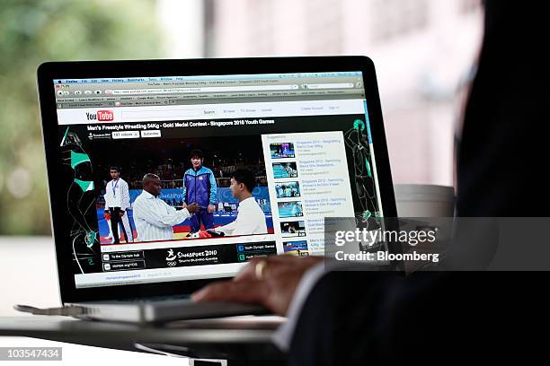 Businessman watches a video clip on Google Inc.�s YouTube website using an Apple Macbook Pro laptop computer, made by Apple Inc., in this arranged...