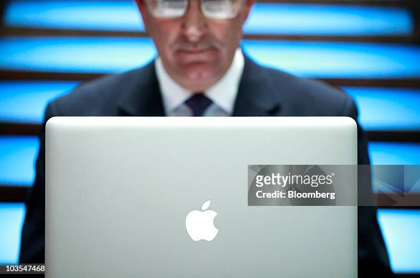 Businessman uses an Apple Macbook Pro laptop computer, made by Apple Inc., to surf the web in this arranged photograph in London, U.K., on Thursday,...